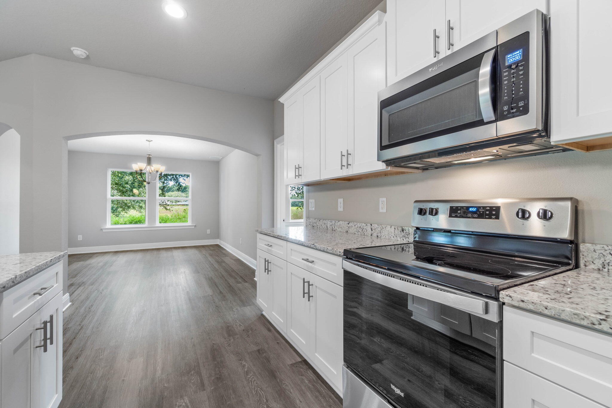 9158 Trident Road Milton, FL 32583 - Photo 16 of 41 a kitchen with stainless steel appliances granite countertop a stove a microwave and cabinets
