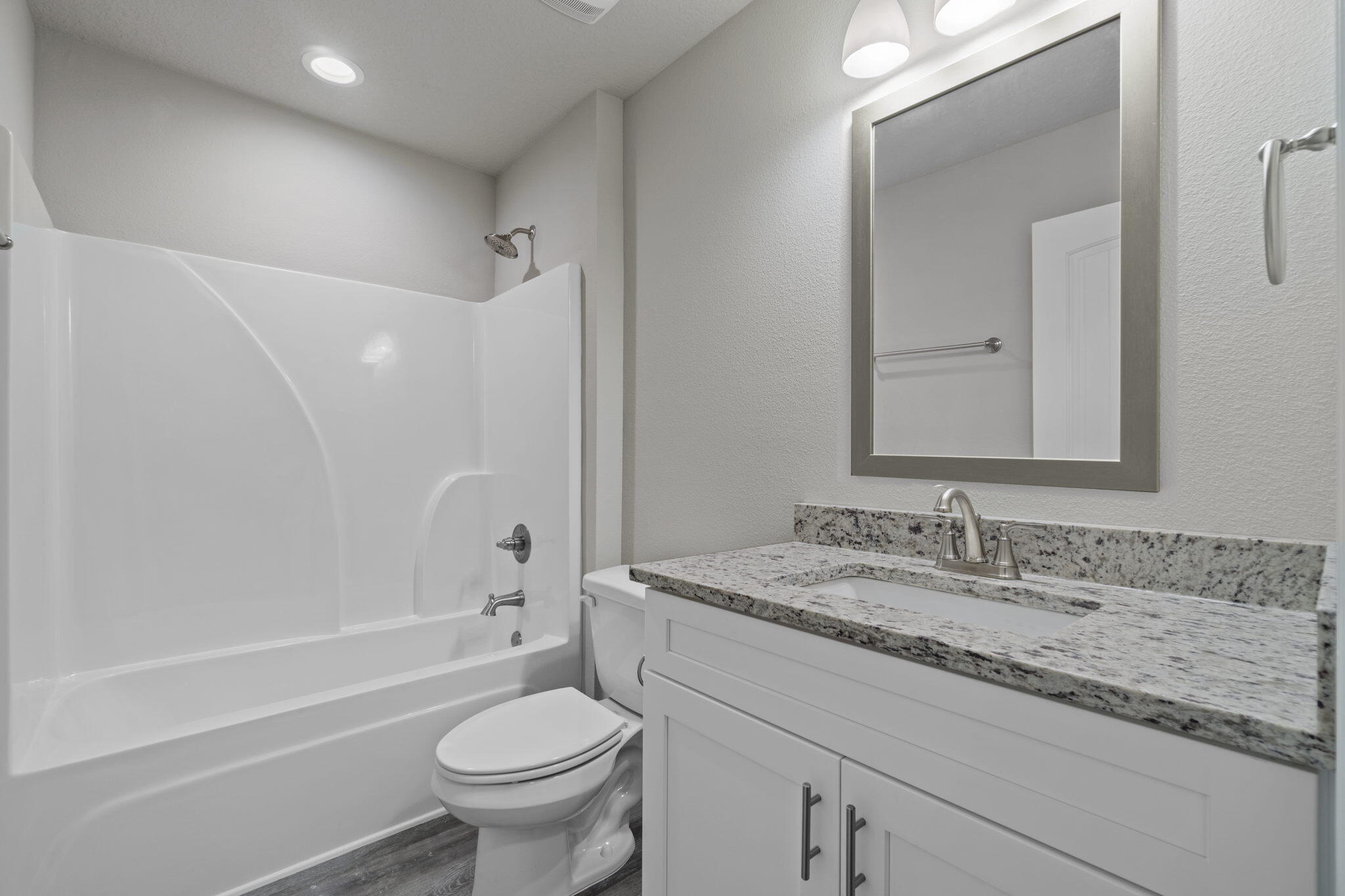9158 Trident Road Milton, FL 32583 - Photo 31 of 41 a bathroom with a granite countertop sink a toilet and a mirror