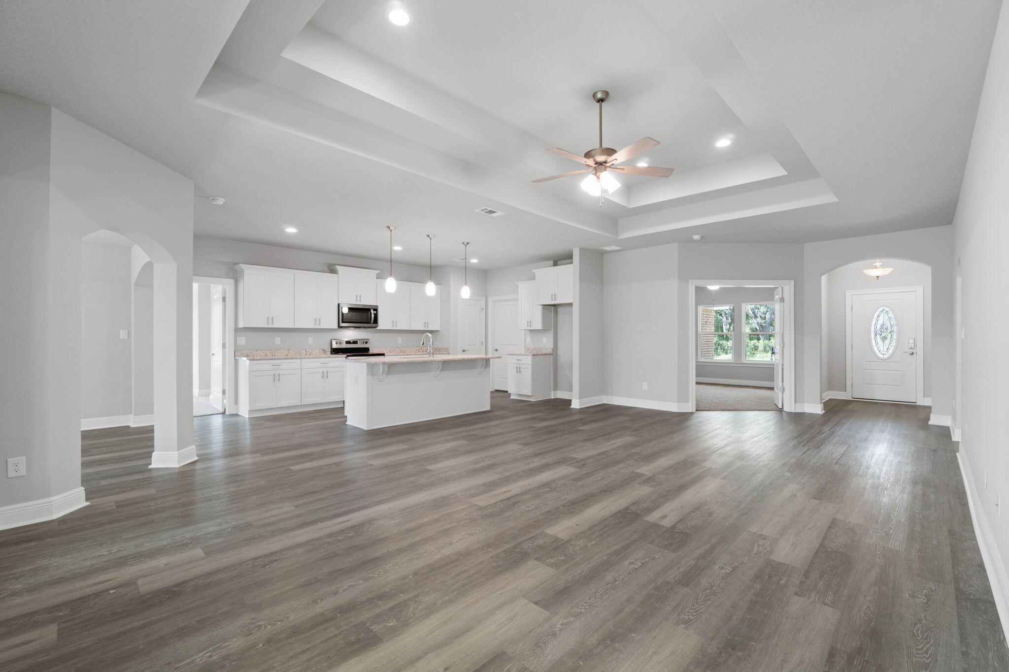 9158 Trident Road Milton, FL 32583 - Photo 9 of 41 a view of an empty room and kitchen with wooden floor
