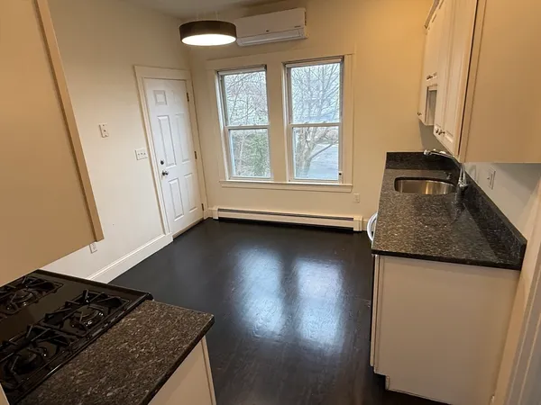 a kitchen with granite countertop a sink stove and refrigerator