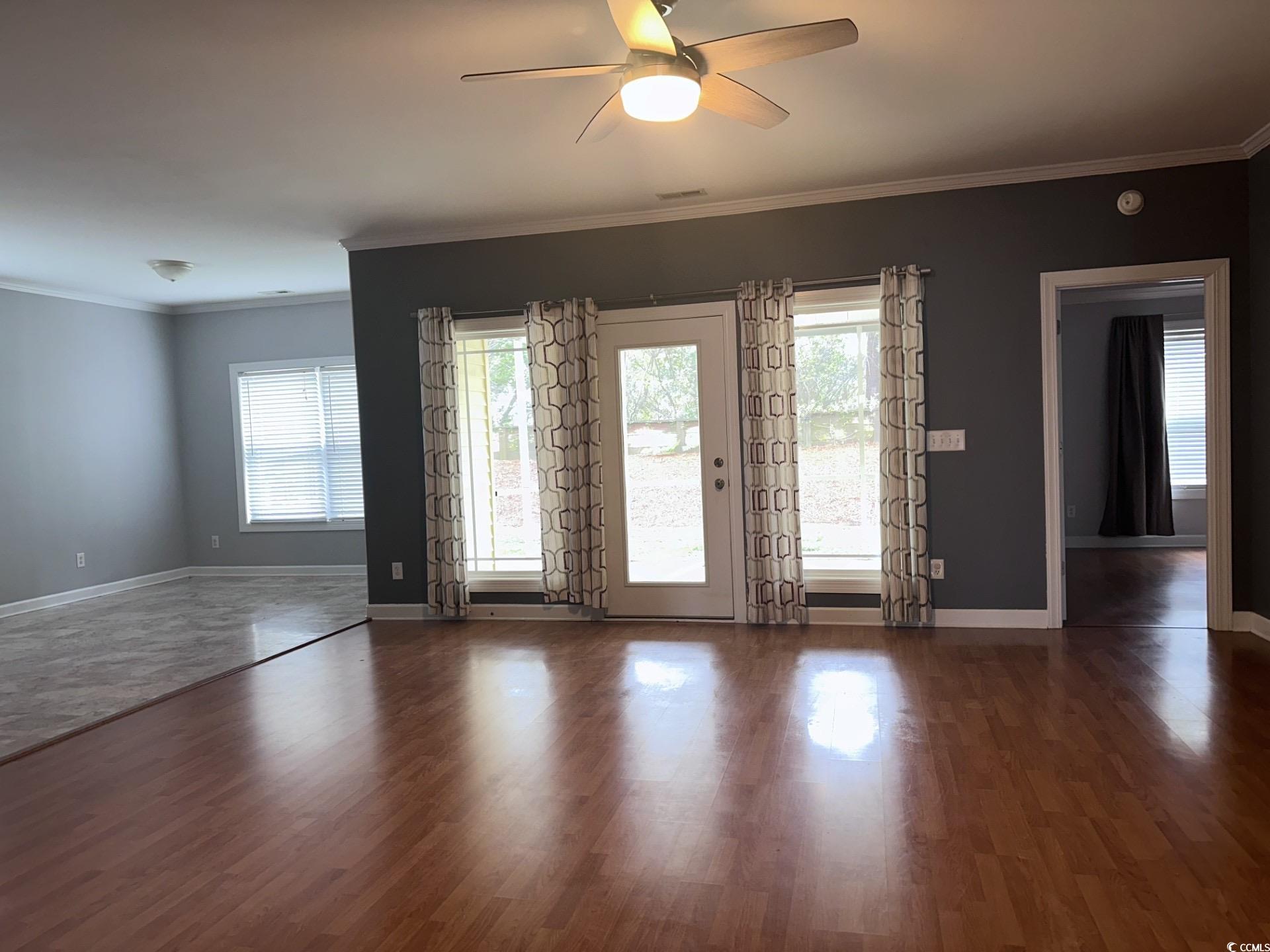 160 Molinia Drive Murrells Inlet, SC 29576 - Photo 5 of 7 Empty room with ornamental molding, dark wood-style flooring, and ceiling fan