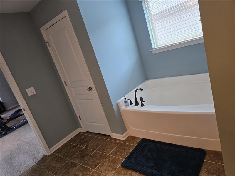 6850 Rocking Horse Lane Cumming, GA 30040 - Photo 13 of 36 a bathroom with a bathtub