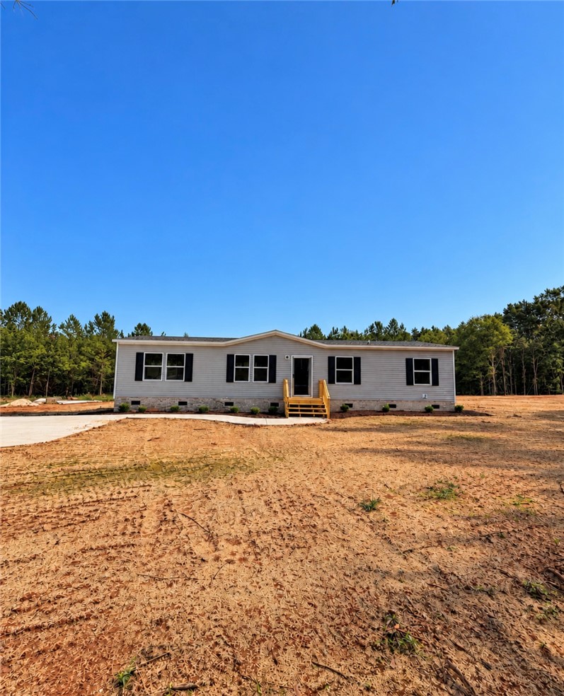 1415 Slaton Road Townville, SC 29689 - Photo 1 of 16 Crisp horizontal siding and classic shutters highlight this newly constructed home against a wooded backdrop.