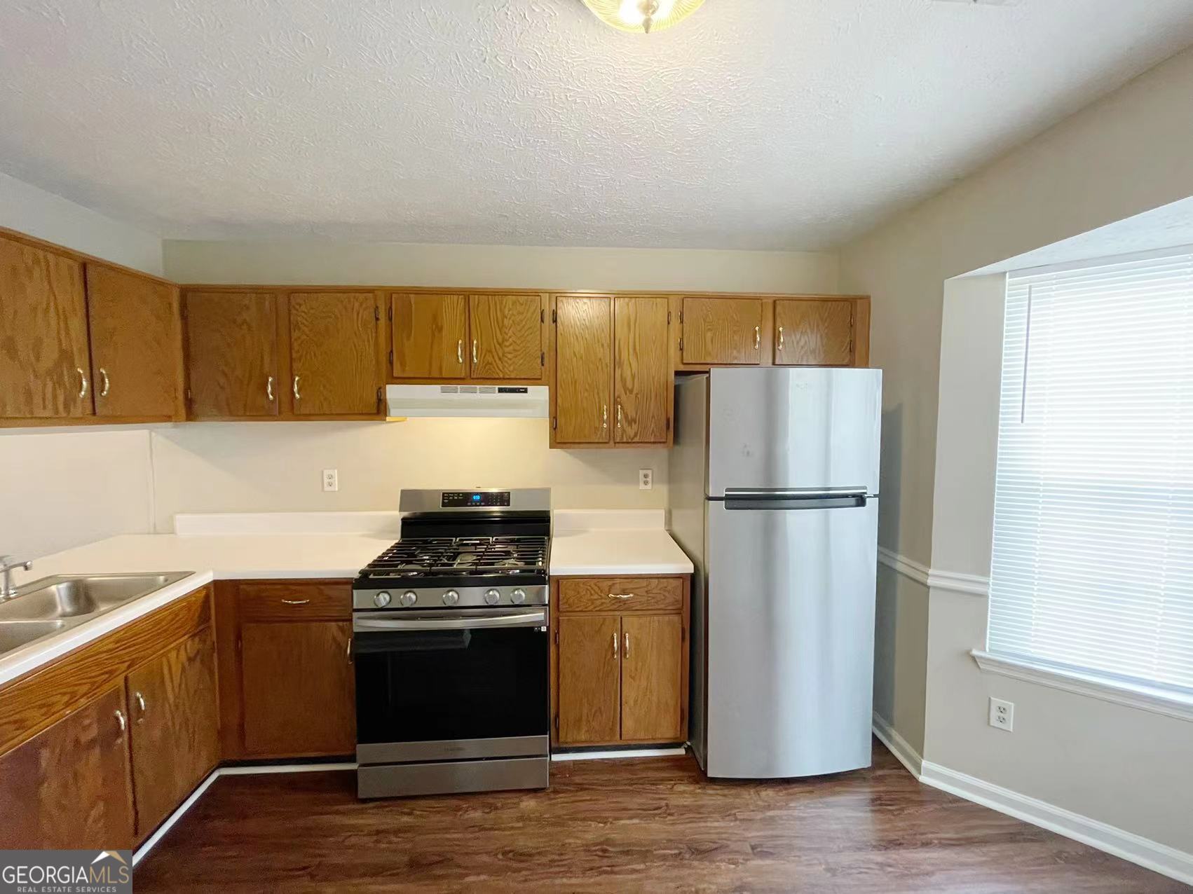 1857 Grant Court Kennesaw, GA 30144 - Photo 4 of 14 a kitchen with a refrigerator stove and wooden cabinets
