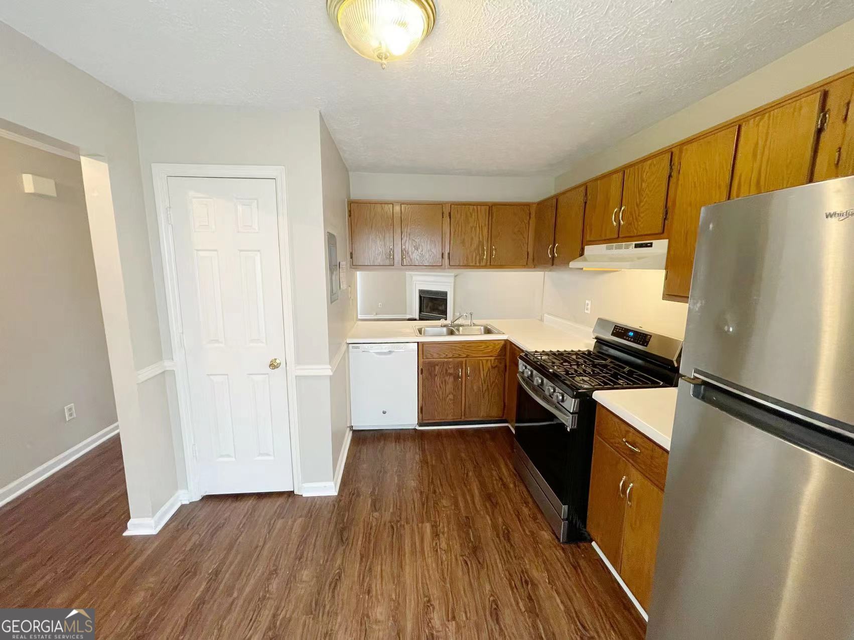 1857 Grant Court Kennesaw, GA 30144 - Photo 5 of 14 a kitchen with a refrigerator a stove top oven and wooden floor
