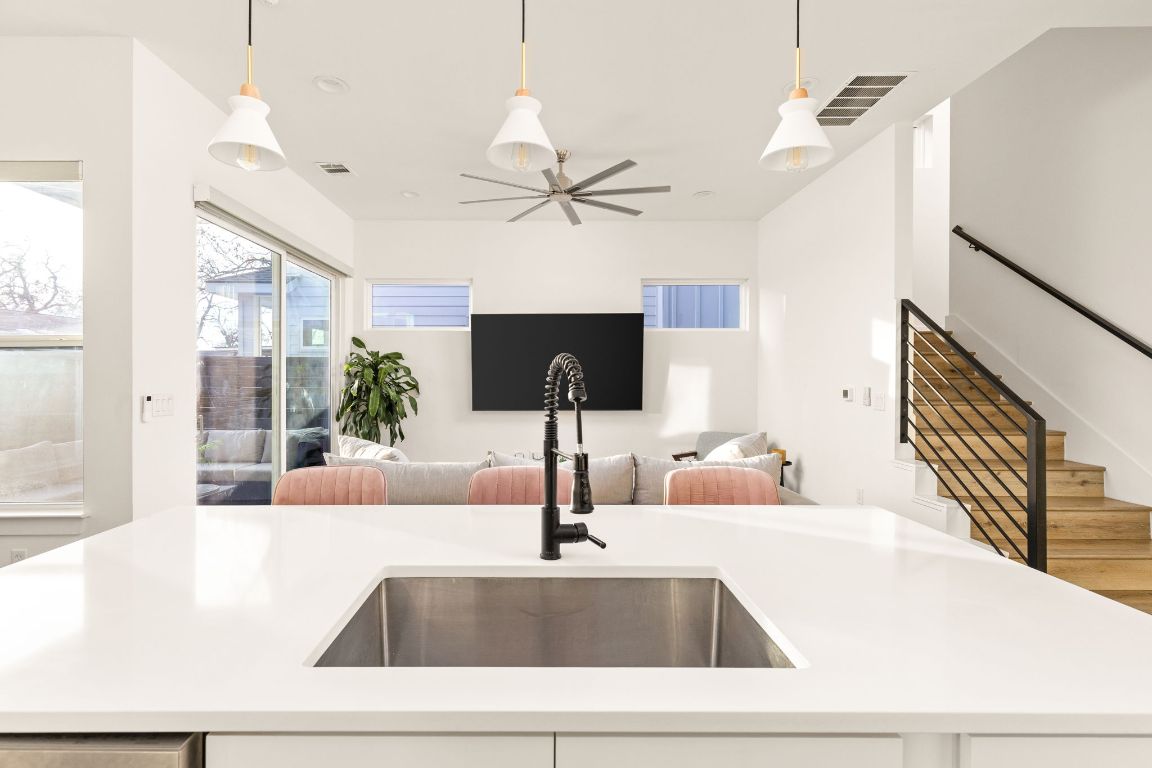 5109 Glissman Road, Unit 1 Austin, TX 78702 - Photo 39 of 39 Kitchen with an island with sink, hanging light fixtures, open floor plan, and light stone counters