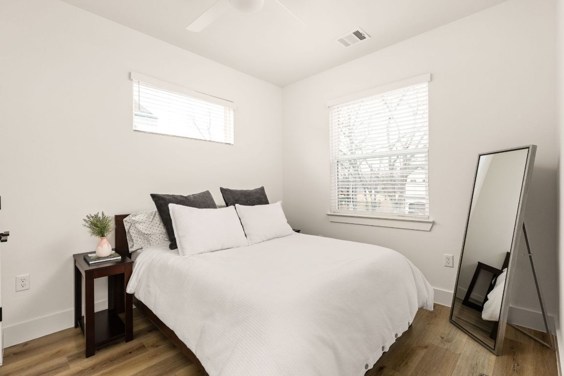 5109 Glissman Road, Unit 1 Austin, TX 78702 - Photo 22 of 39 Bedroom with multiple windows, dark wood-style floors, and ceiling fan