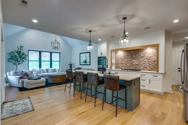 a kitchen with stainless steel appliances kitchen island granite countertop a stove a sink and a refrigerator