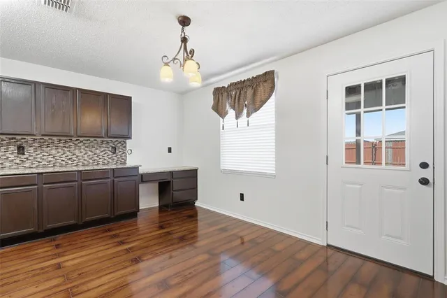 a kitchen with granite countertop wooden floors and white cabinets