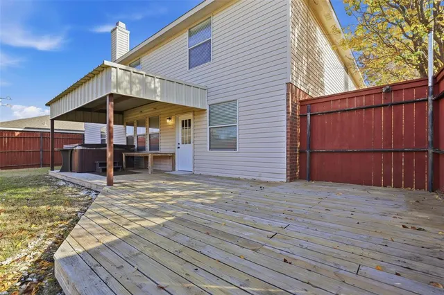 a view of a chair and wooden floor in front of house