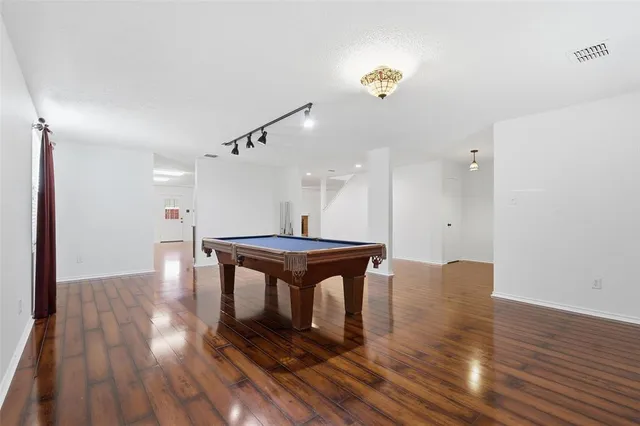 a room with wooden floor and pool table