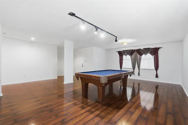 a room with wooden floors and pool table