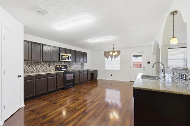 a large kitchen with a lot of counter space and stainless steel appliances
