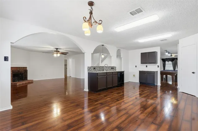 a view of a kitchen center island wooden floor stainless steel appliances and cabinets