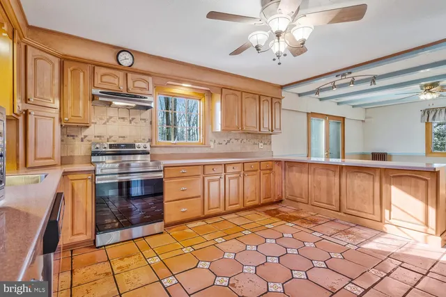 a kitchen with stainless steel appliances granite countertop a stove a sink and a refrigerator