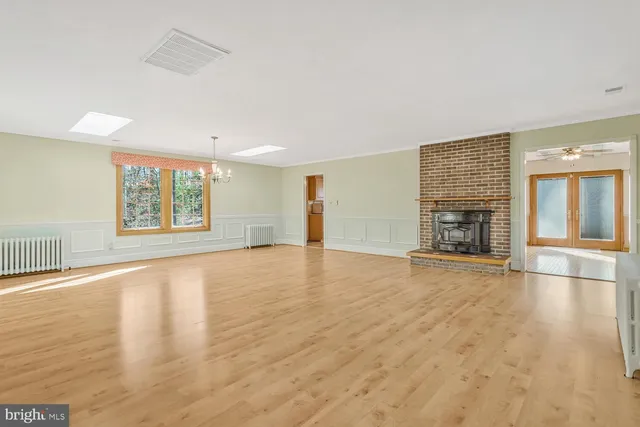 an empty room with wooden floor and fireplace