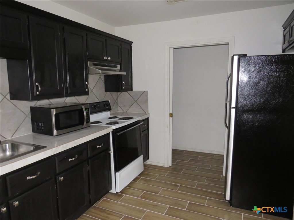4608 Bowles Drive, Unit D Killeen, TX 76549 - Photo 4 of 15 a kitchen with a refrigerator stove and cabinets