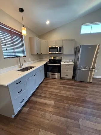 a large kitchen with kitchen island a sink dishwasher a refrigerator and a stove