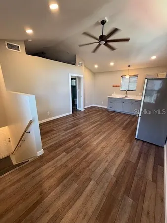 a view of a livingroom with a ceiling fan and wooden floor
