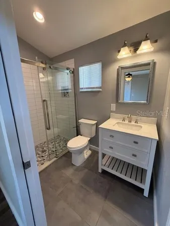 a bathroom with a double vanity sink mirror and toilet
