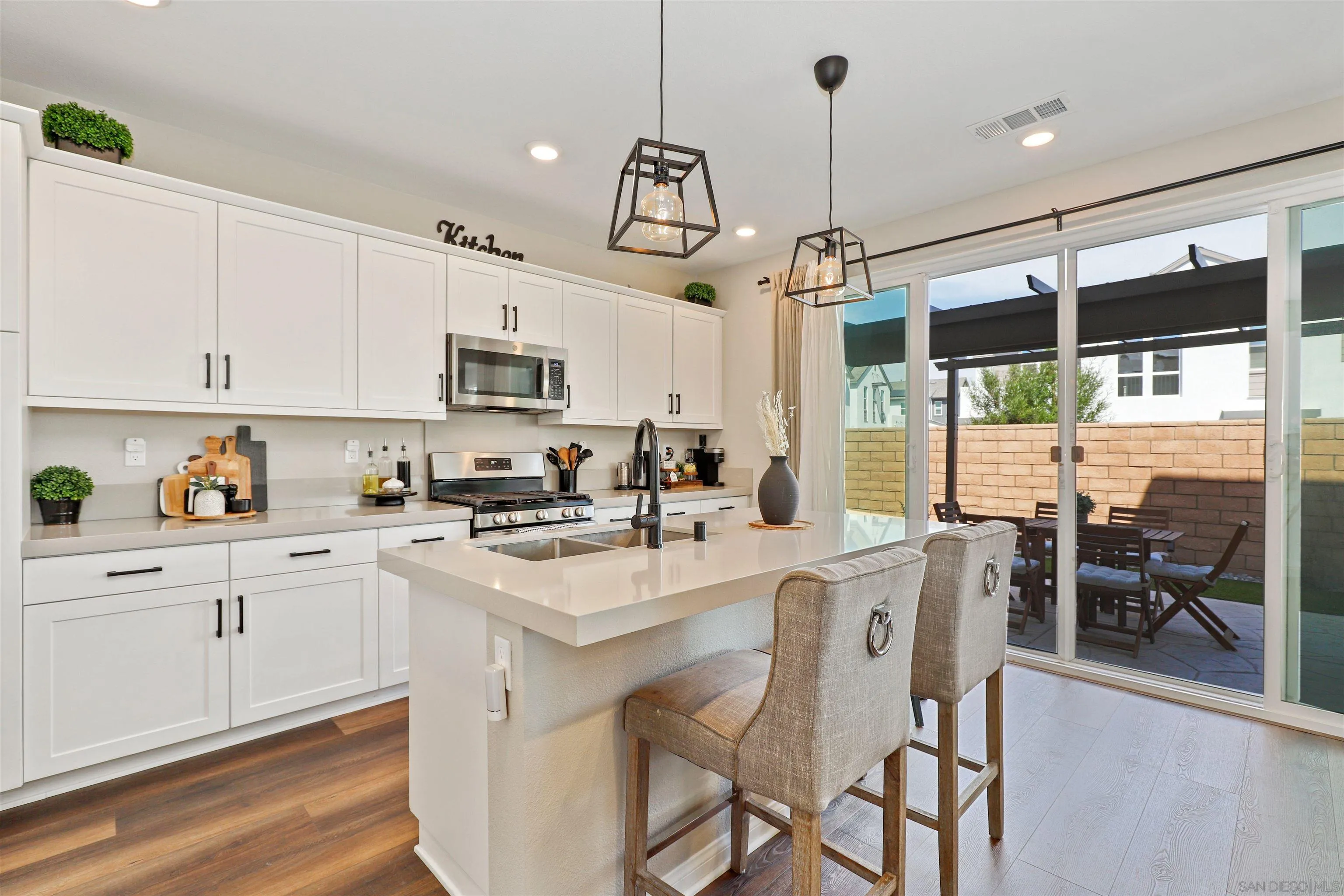 1799 Whitmore Loop Chula Vista, CA 91913 - Photo 10 of 36 a kitchen with stainless steel appliances granite countertop a stove a sink a refrigerator a center island a dining table and chairs