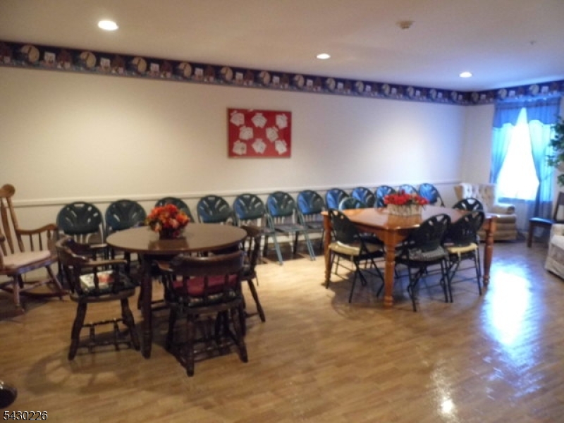 1302 Richmond Road, Unit 302 West Milford, NJ 07480 - Photo 17 of 21 a view of a dining room with furniture and wooden floor