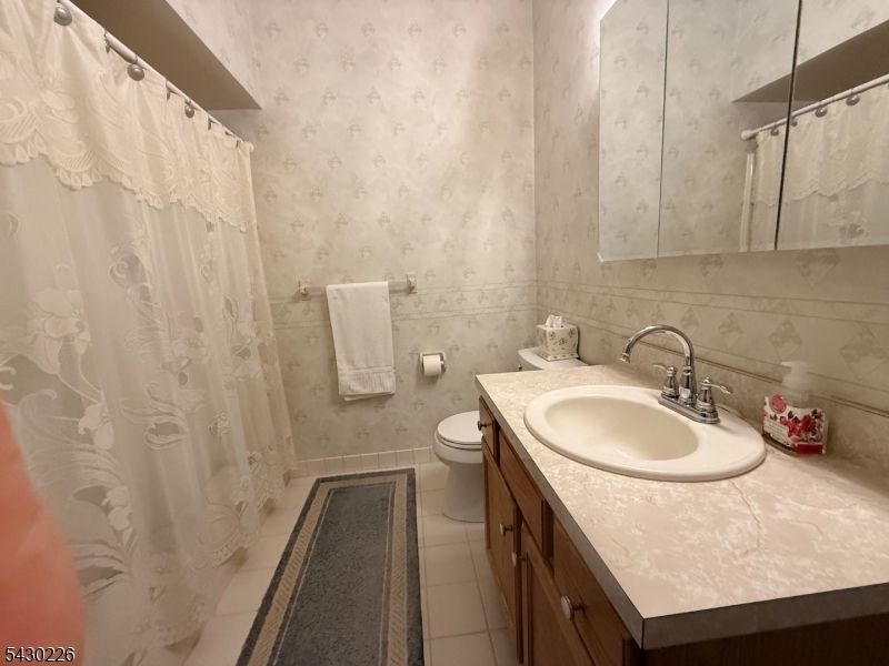 1302 Richmond Road, Unit 302 West Milford, NJ 07480 - Photo 10 of 21 a bathroom with a sink a toilet and shower