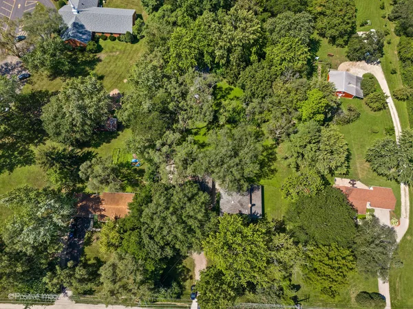 an aerial view of residential house with outdoor space and trees all around
