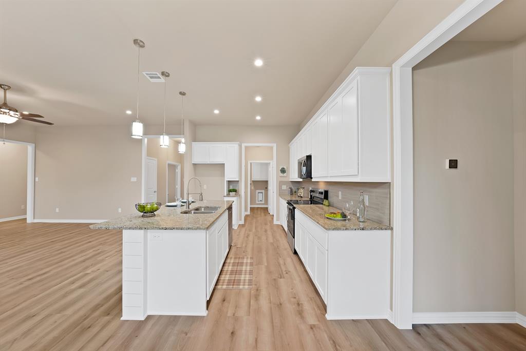 106 Panther Loop Mabank, TX 75147 - Photo 14 of 34 a view of a kitchen with kitchen island a counter top space a sink a wooden floor and cabinets