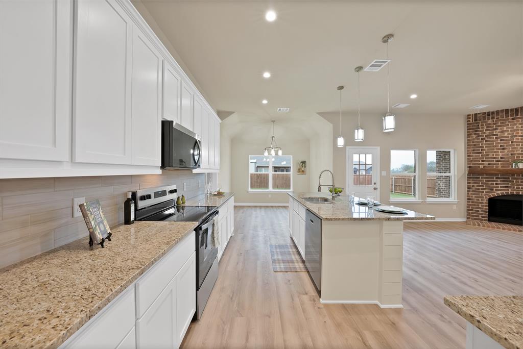 106 Panther Loop Mabank, TX 75147 - Photo 14 of 34 a kitchen with granite countertop a sink a counter top space appliances and cabinets