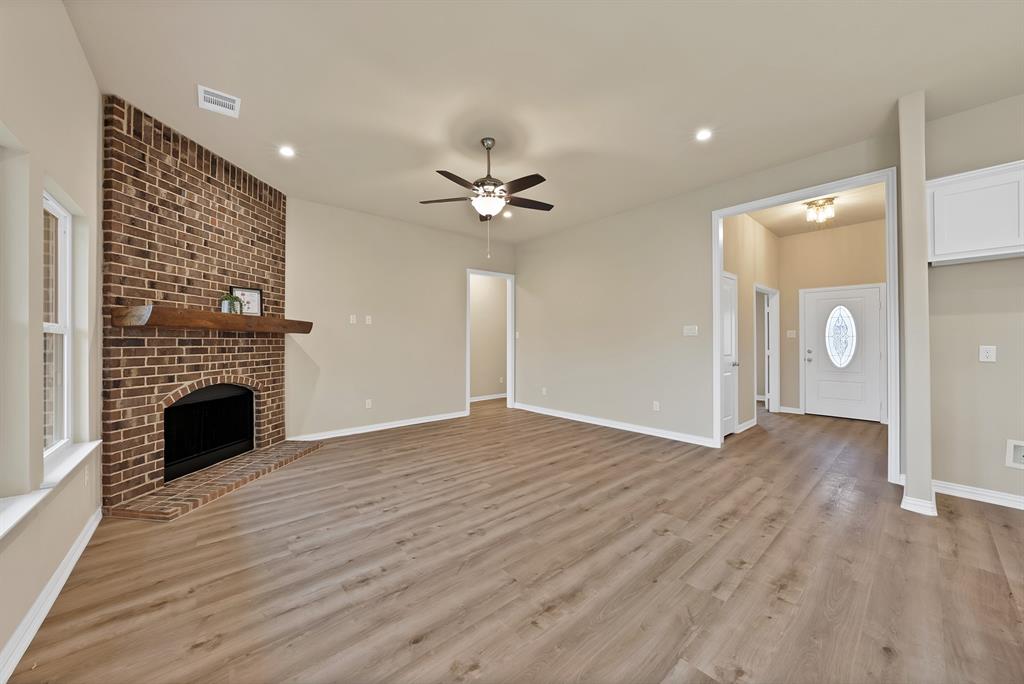 106 Panther Loop Mabank, TX 75147 - Photo 16 of 34 a view of an empty room with wooden floor and a fireplace