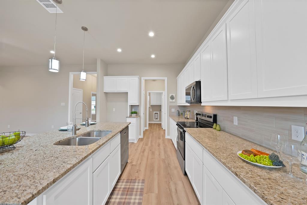 106 Panther Loop Mabank, TX 75147 - Photo 10 of 34 a large kitchen with kitchen island a large counter top space a sink stainless steel appliances and cabinets