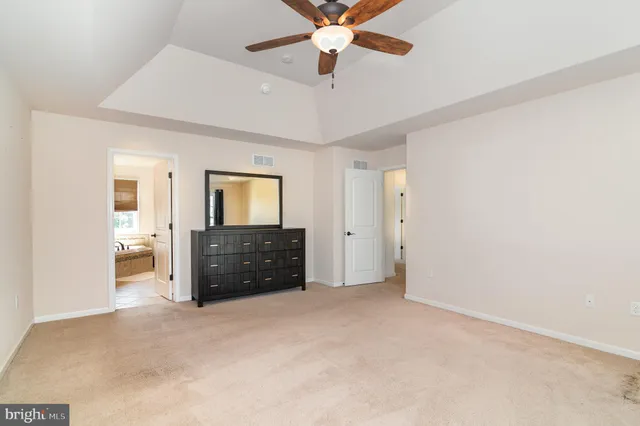 an empty room with closet and a chandelier fan