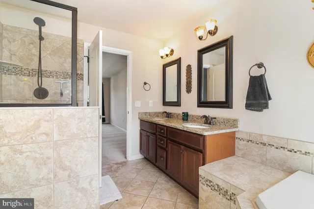 a bathroom with a tub sink and mirror