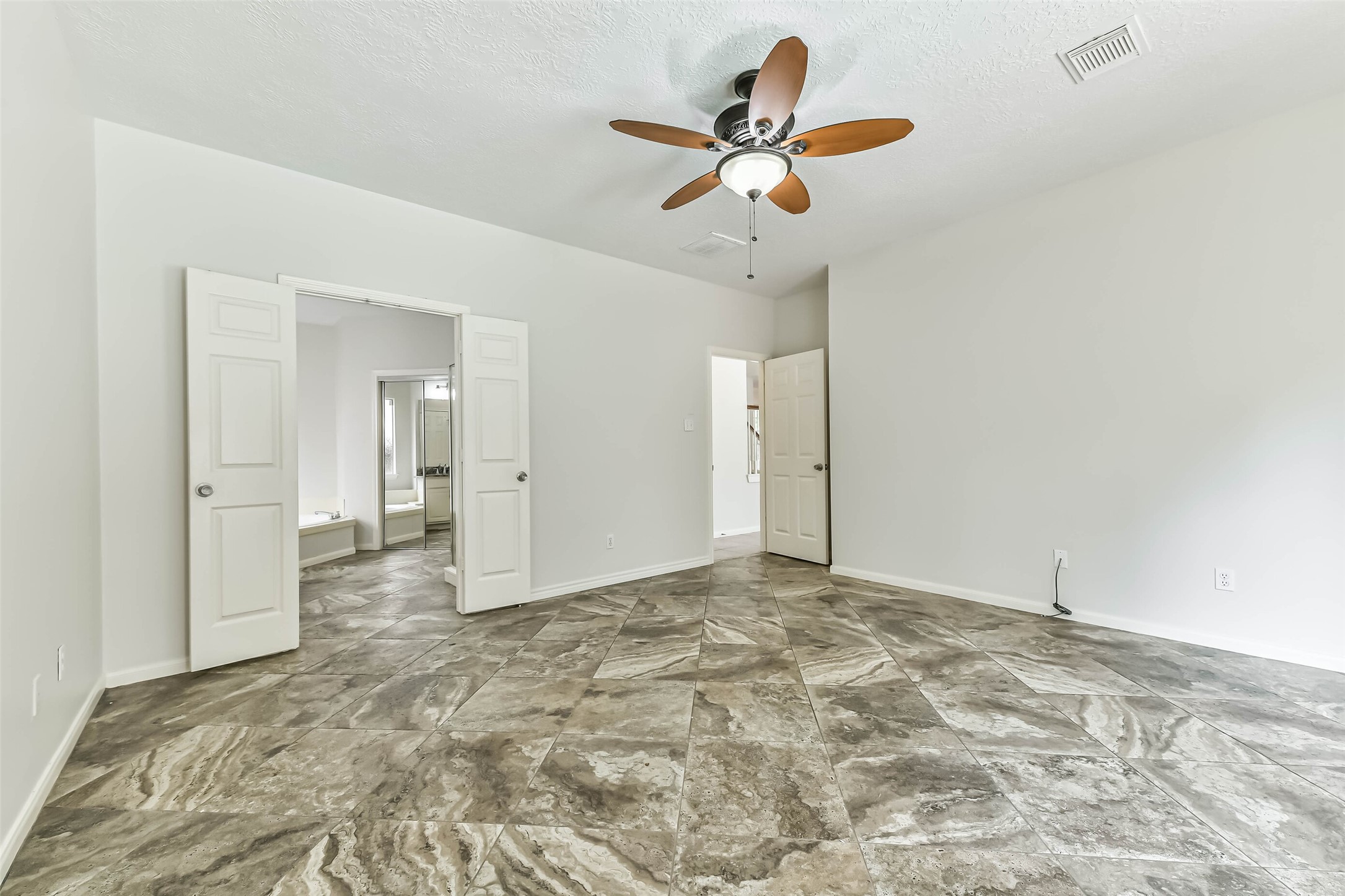 6338 Maple Spring Place Humble, TX 77346 - Photo 27 of 50 Ease into the day with your bedroom and private bath comfortably connected through double doors. Generous wall space offers flexibility for furniture placement, letting you create a retreat that feels calm, organized and entirely your own.