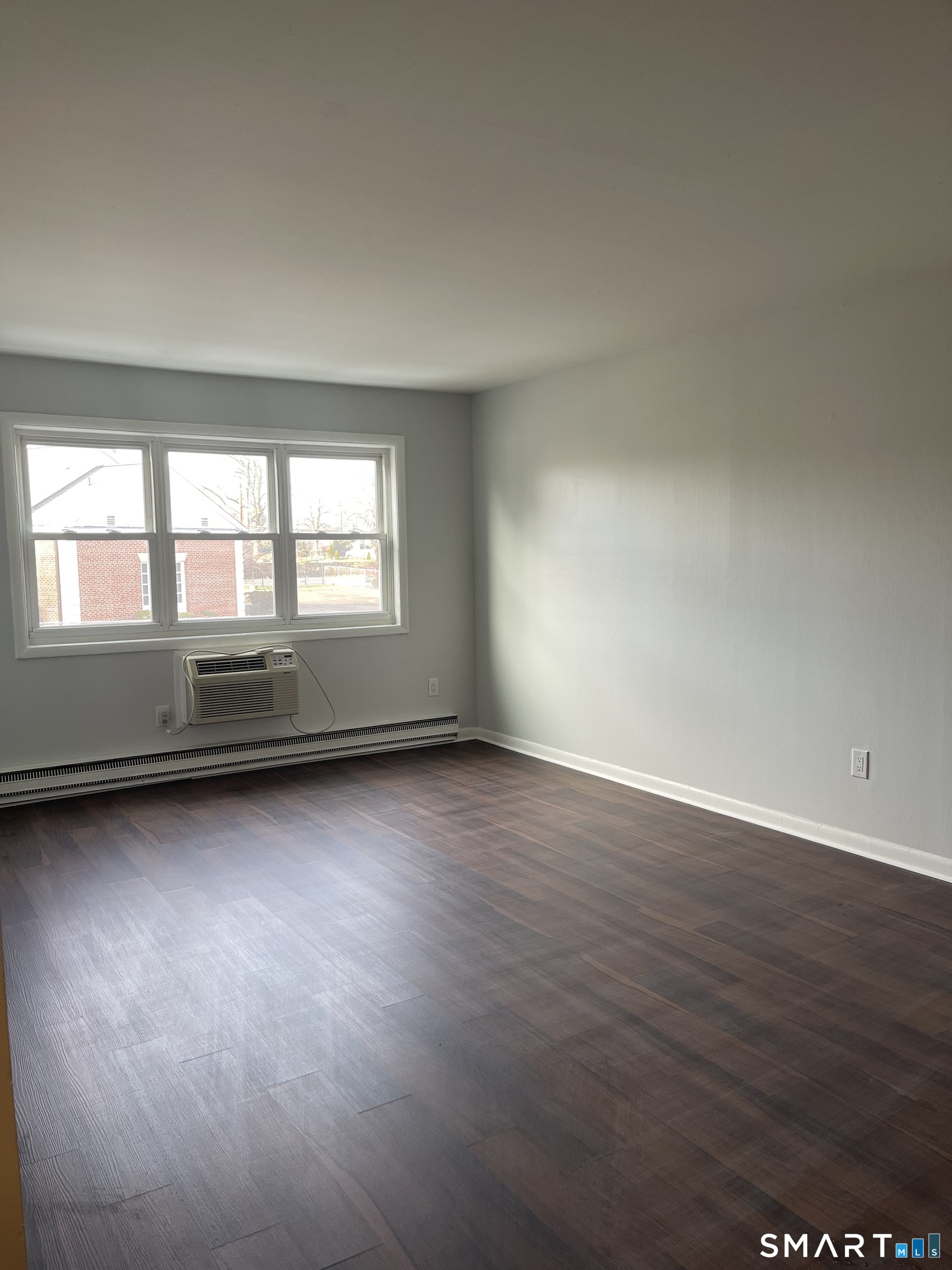 45 Monroe Street, Unit B2 Bridgeport, CT 06605 - Photo 7 of 12 an empty room with wooden floor and windows