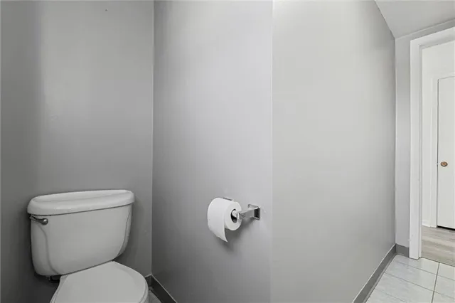 a white toilet sitting next to a white wall