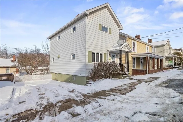a view of a house with a yard covered in snow