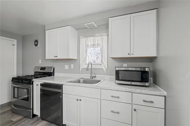 a kitchen with white cabinets and stainless steel appliances