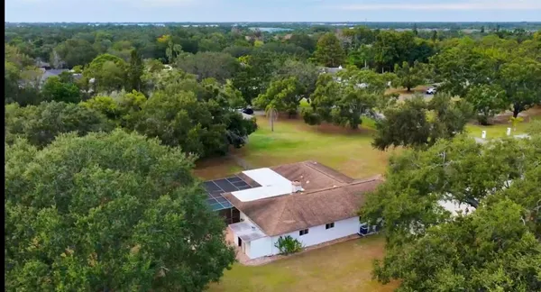 an aerial view of a house with a garden and lake view