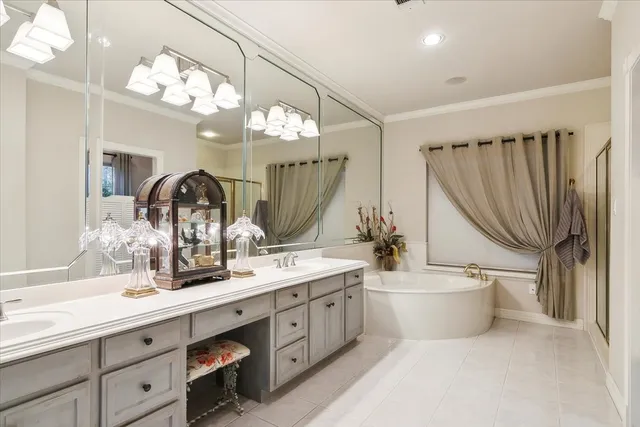 a bathroom with a double vanity sink mirror and bathtub