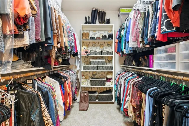 a view of walk in closet with clothes and shoes