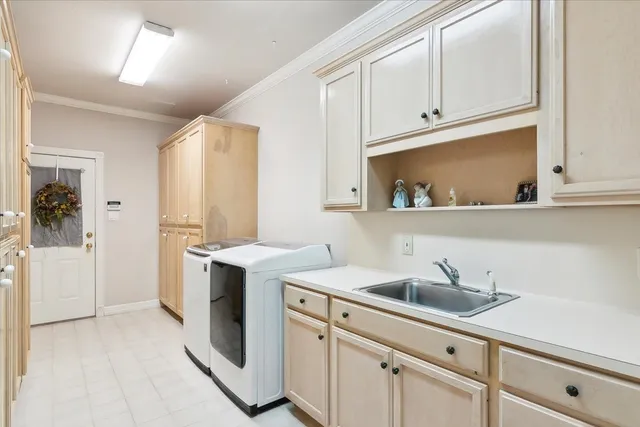 a kitchen with white cabinets and sink