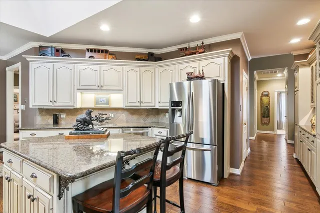 a kitchen with stainless steel appliances granite countertop a refrigerator and a stove top oven