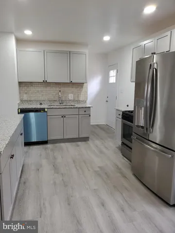 a kitchen with granite countertop a refrigerator and a sink