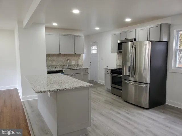a kitchen with a refrigerator a sink and a microwave