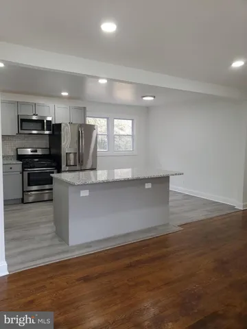 a kitchen with stainless steel appliances granite countertop a refrigerator a stove a sink and a microwave