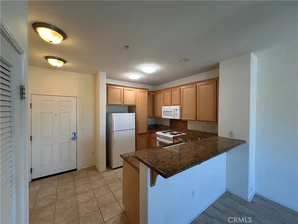 a kitchen with kitchen island granite countertop cabinets and refrigerator