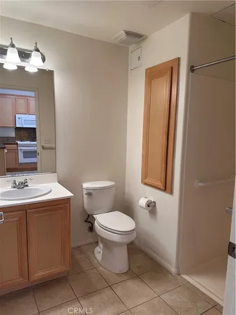a bathroom with a toilet sink vanity and mirror