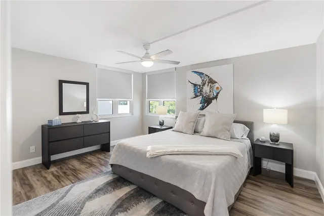 a spacious bedroom with a bed and a ceiling fan